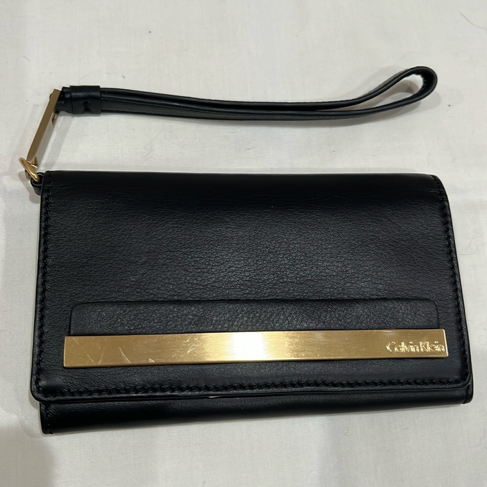 Calvin Klein wristlet in black with gold accents.